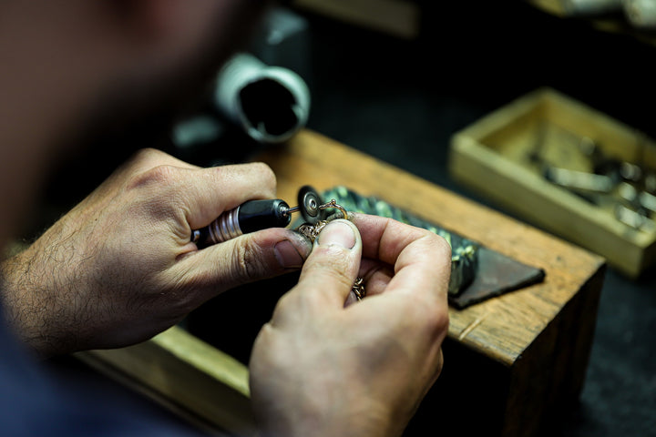 Our bench jeweler working with his hands.